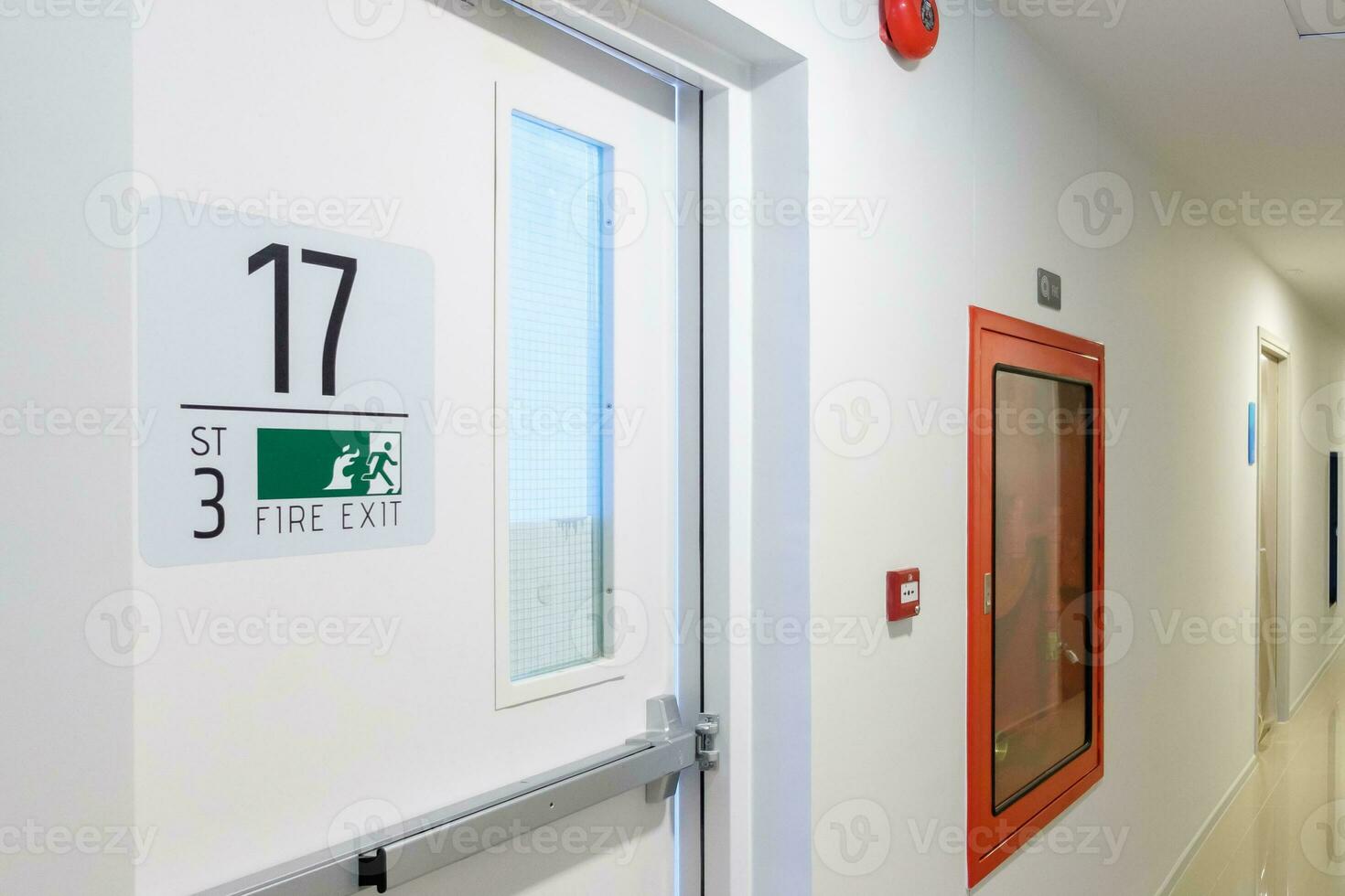 Fire extinguisher system on the wall with Fire Exit door sign for emergency. Stairwell fire for escape in building or apartment photo