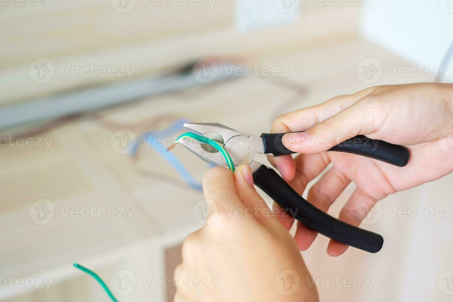 Electrician cuts electrical wires with pliers, Wiring cables installation for socket plug. Fixing, Renovation, Repair, service and development of home and apartment concepts photo