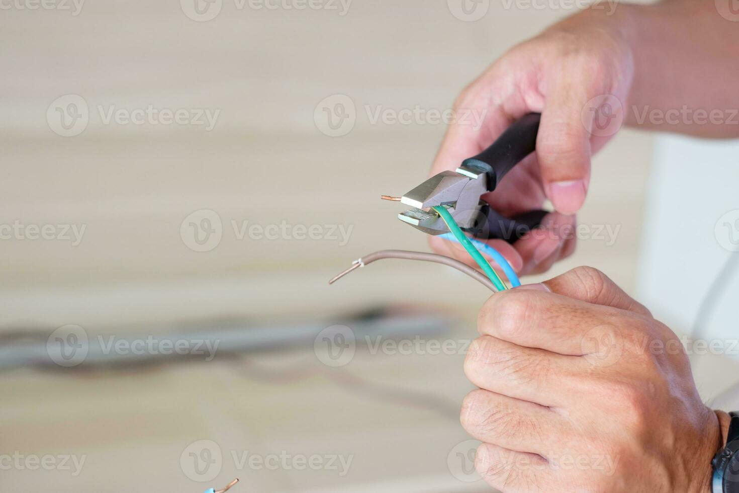 Electrician cuts electrical wires with pliers, Wiring cables installation for socket plug. Fixing, Renovation, Repair, service and development of home and apartment concepts photo