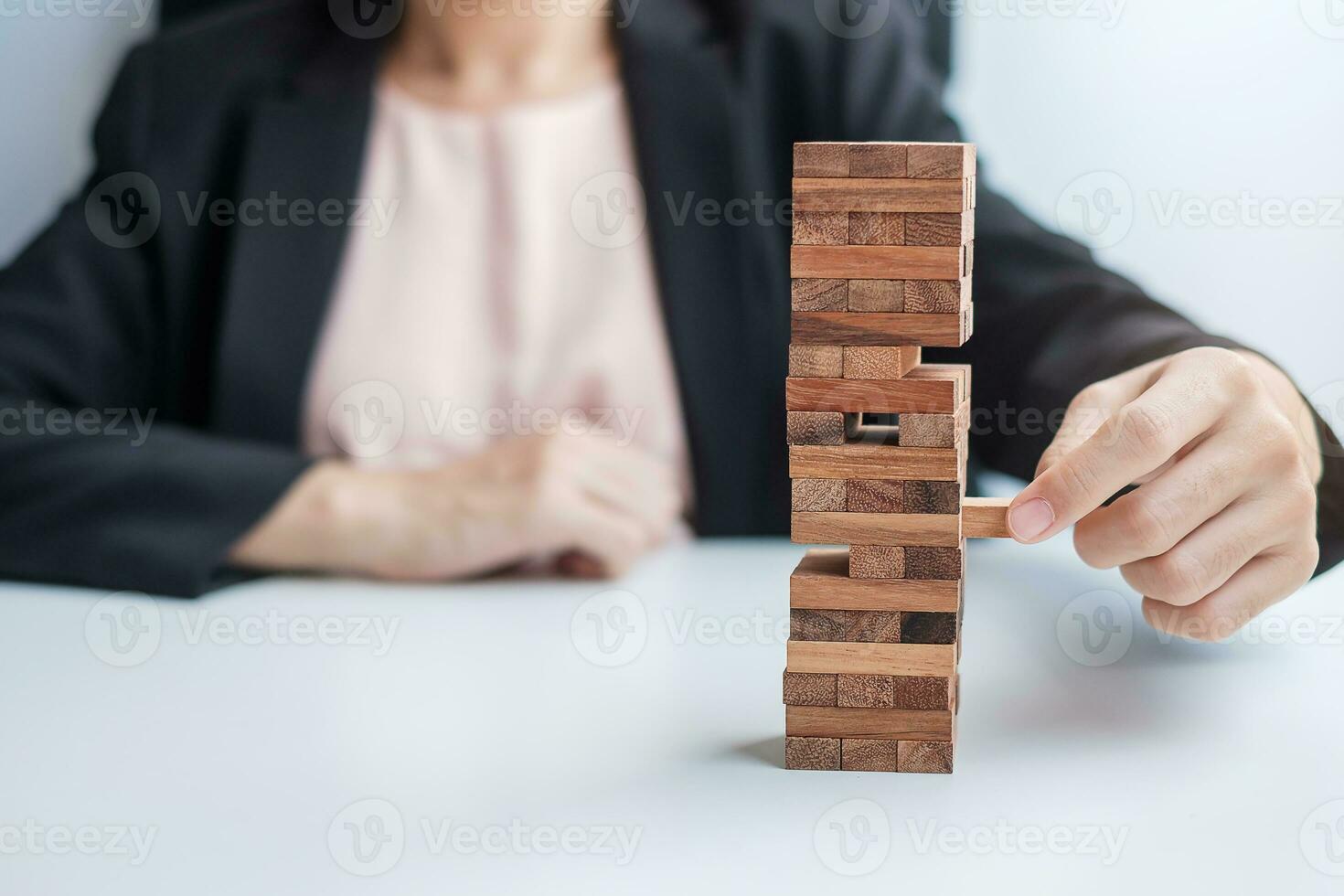 Businesswoman hand placing or pulling wooden block on the tower. Business planning, Risk Management, Solution and strategy Concepts photo