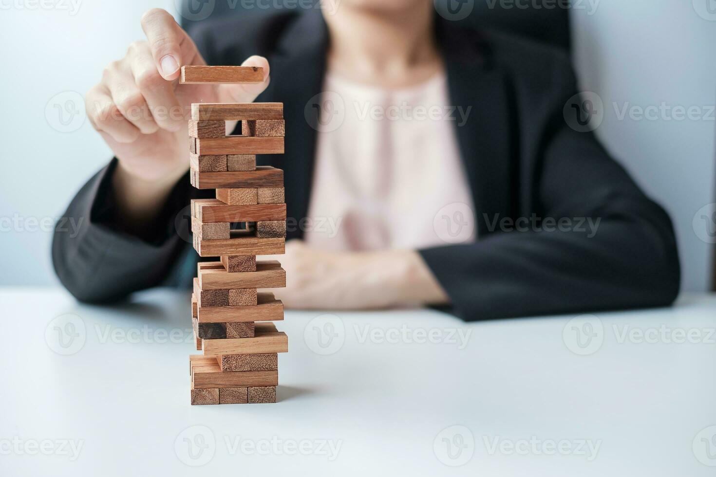 Businesswoman hand placing or pulling wooden block on the tower. Business planning, Risk Management, Solution and strategy Concepts photo