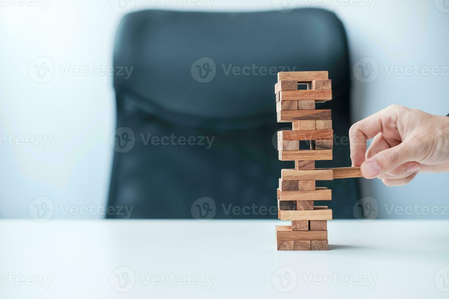 Businessman hand placing or pulling wooden block on the tower. Business planning, Risk Management, Solution and strategy Concepts photo