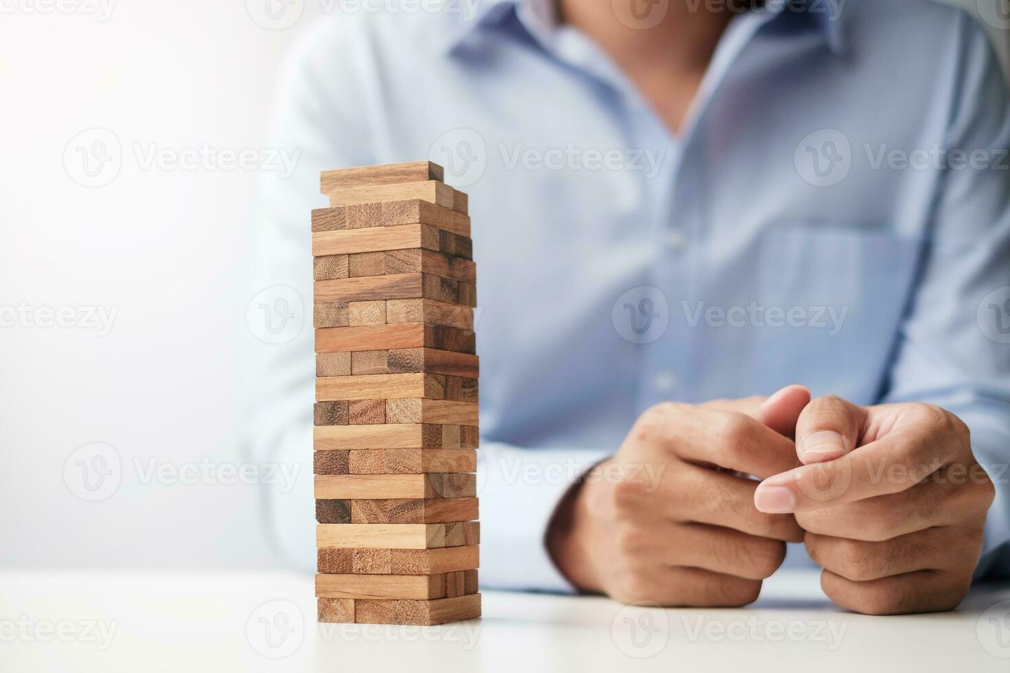 Businessman hand placing or pulling wooden block on the tower. Business planning, Risk Management, Solution and strategy Concepts photo