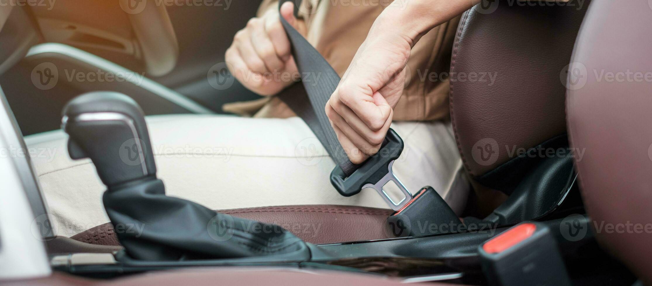 woman driver hand fastening seat belt during sitting inside a car and driving in the road. safety, trip, journey and transport concept photo