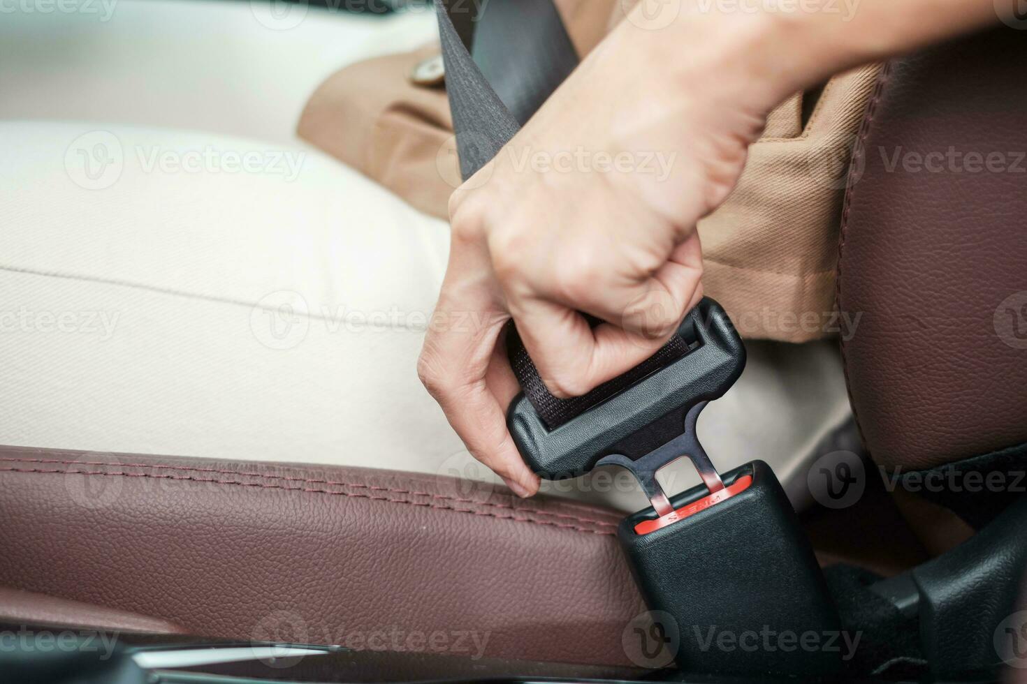 woman driver hand fastening seat belt during sitting inside a car and driving in the road. safety, trip, journey and transport concept photo