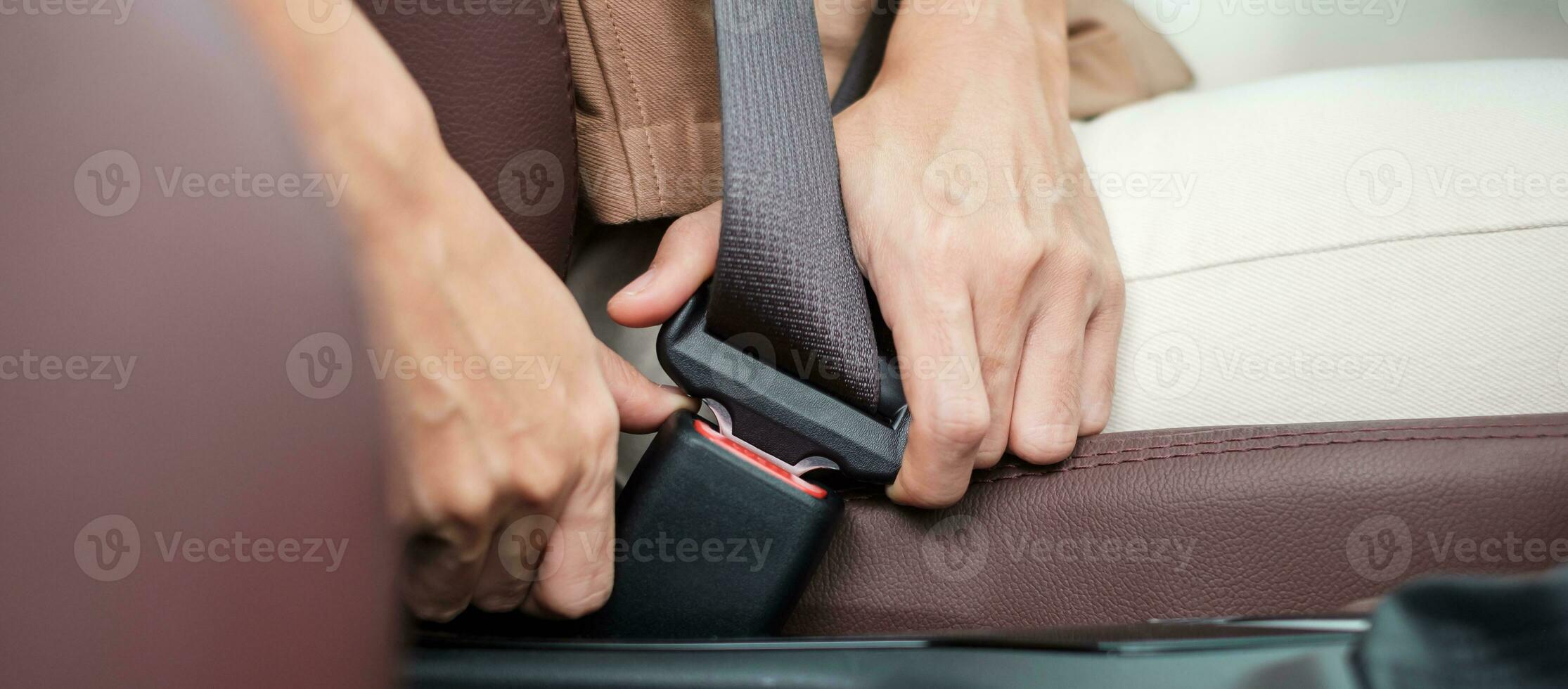 woman driver hand fastening seat belt during sitting inside a car and driving in the road. safety, trip, journey and transport concept photo