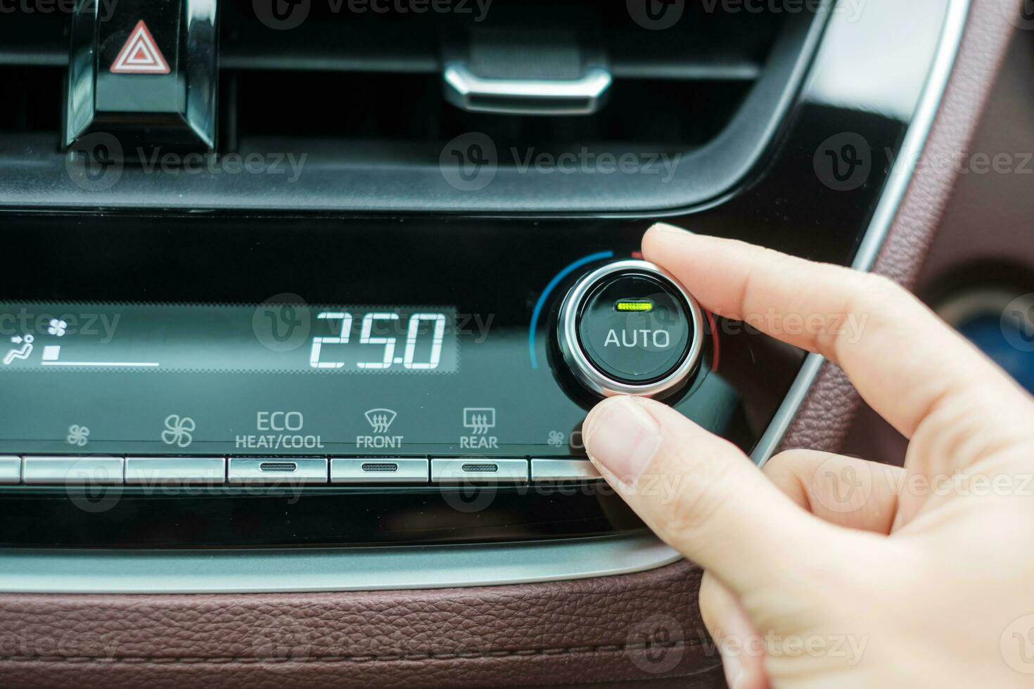 Woman hand adjusting temperature the air flowing during driving car on the road, air conditioner cooling system inside the car. Adjust, temperature and transport concept photo