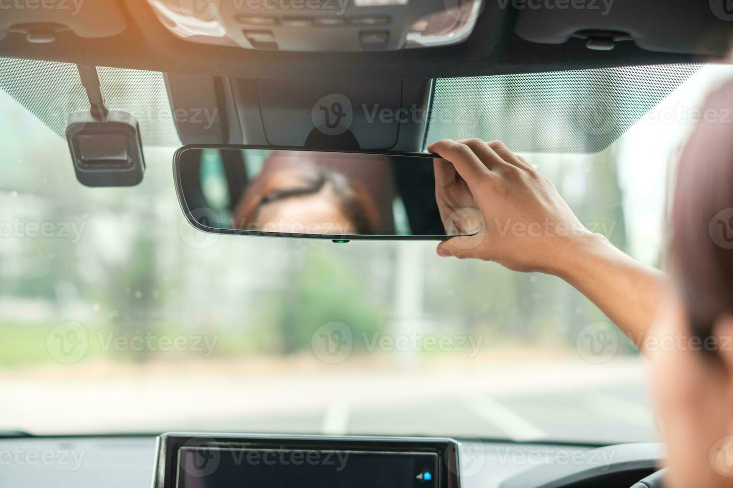 woman driver adjusting rear view mirror a car. Journey, trip and safety Transportation concepts photo