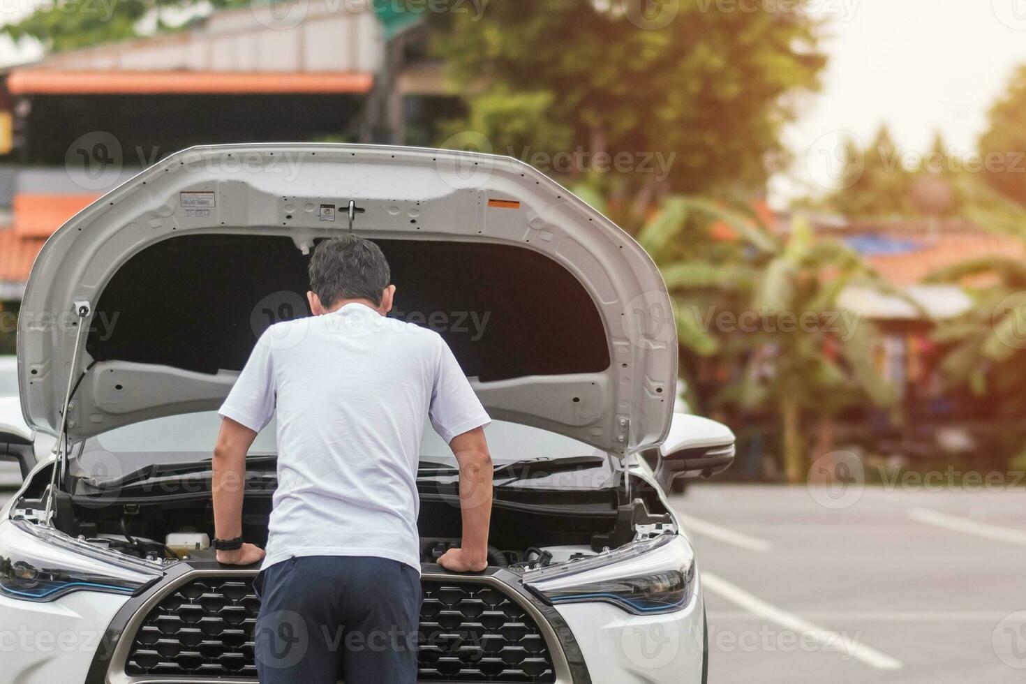 man driver standing near a problem car. Breakdown or broken car on road. Vehicle Insurance, maintenance and service concept photo