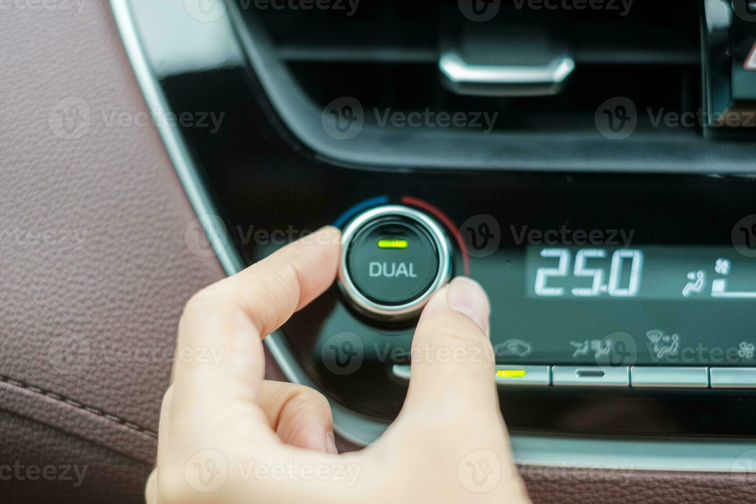 Woman hand adjusting temperature the air flowing during driving car on the road, air conditioner cooling system inside the car. Adjust, temperature and transport concept photo