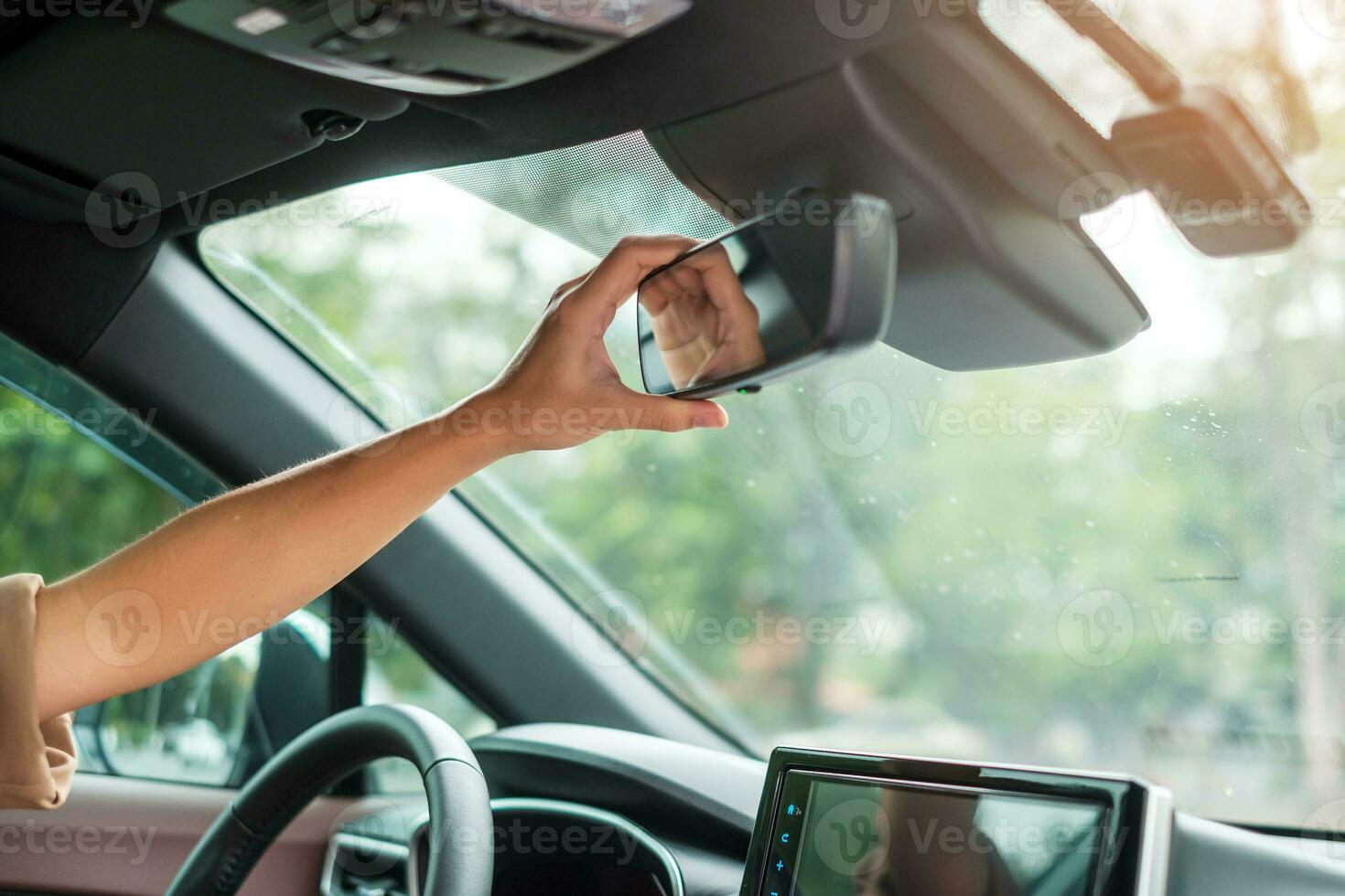 woman driver adjusting rear view mirror a car. Journey, trip and safety Transportation concepts photo