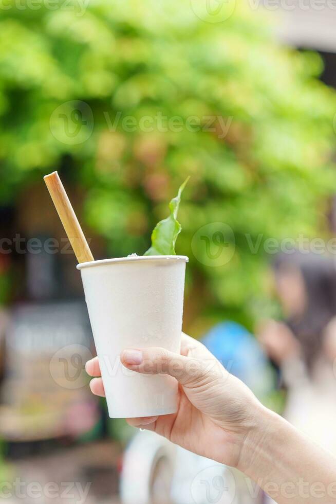 mano participación papel taza de herbario bebida con loto pétalo y té hoja, es el más popular bebida para turistas en hoi un antiguo pueblo en central Vietnam foto