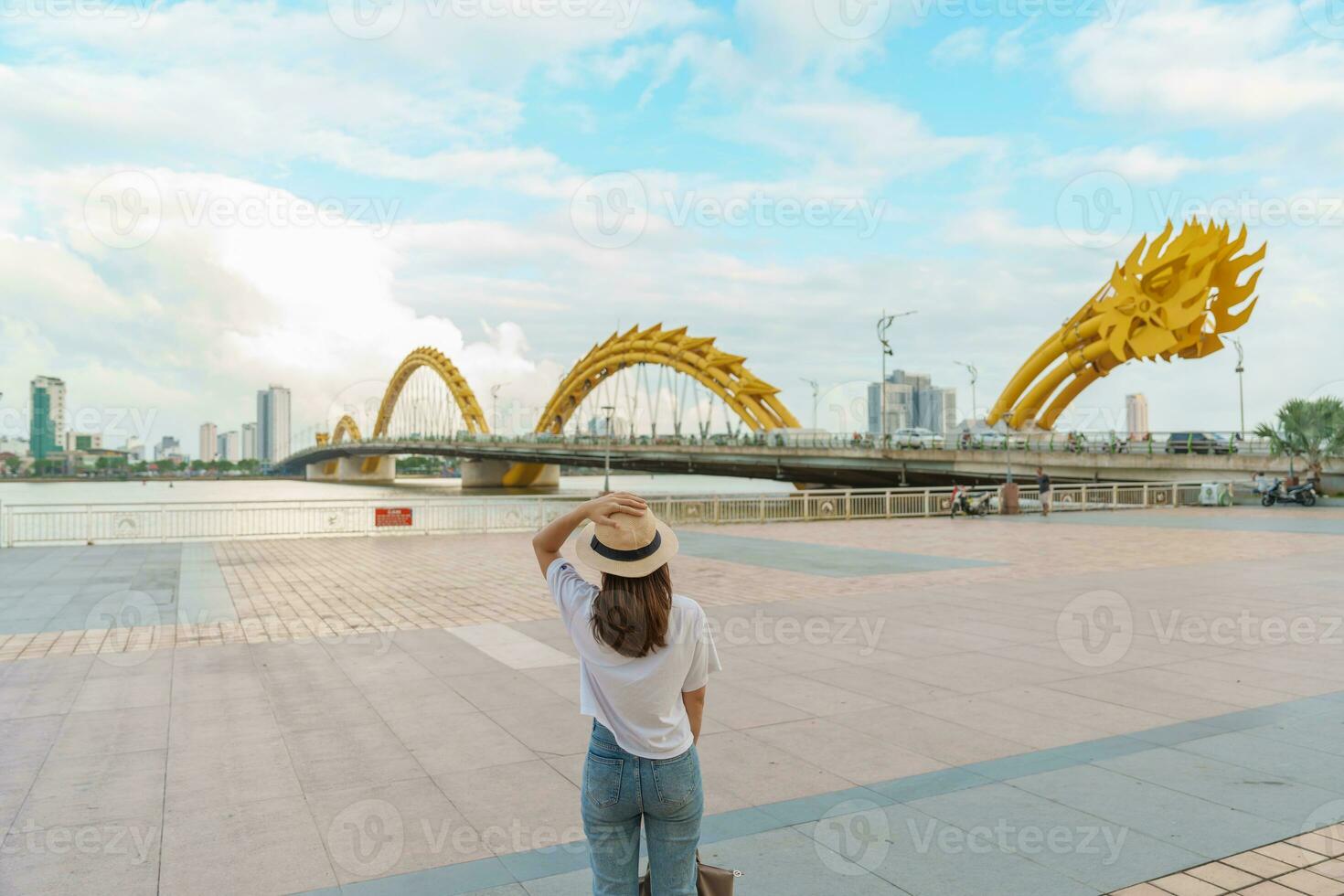 Woman Traveler visiting in Da Nang city. Tourist sightseeing the river view with Dragon bridge. Landmark and popular for tourist attraction. Vietnam and Southeast Asia travel concept photo