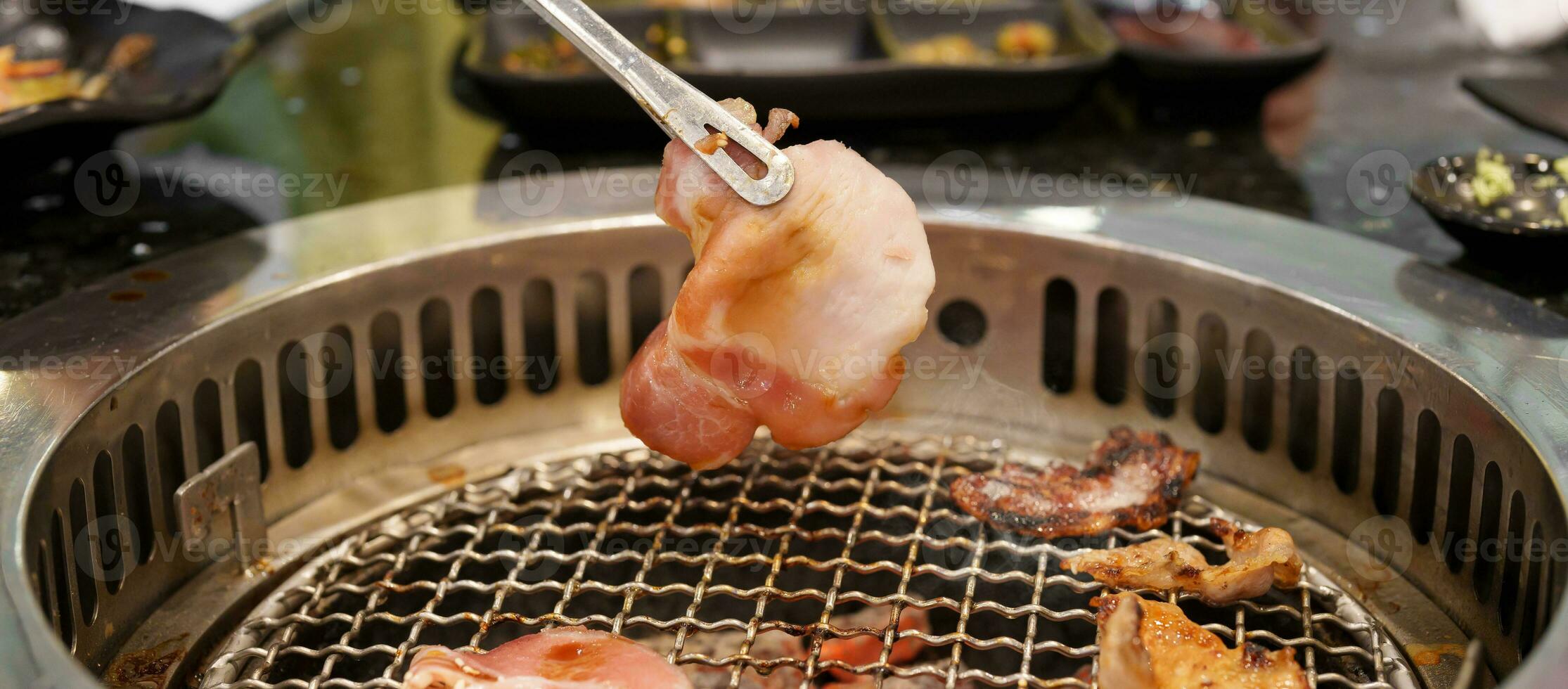 Hand Grilling meat pork on stove serve in restaurant. Japanese food and Korean BBQ traditional style photo