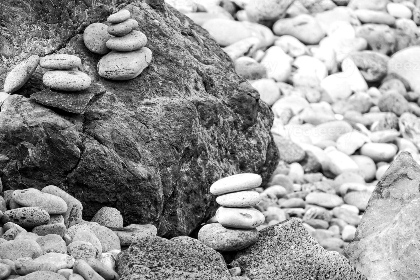 interesting tower made of stones arranged on the shore of the ocean on a warm summer's day photo