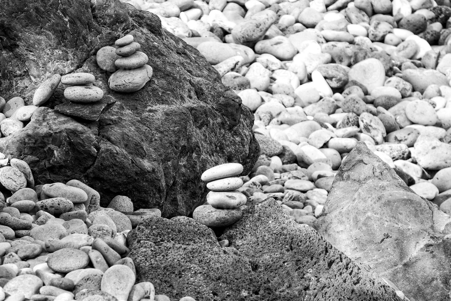 interesting tower made of stones arranged on the shore of the ocean on a warm summer's day photo