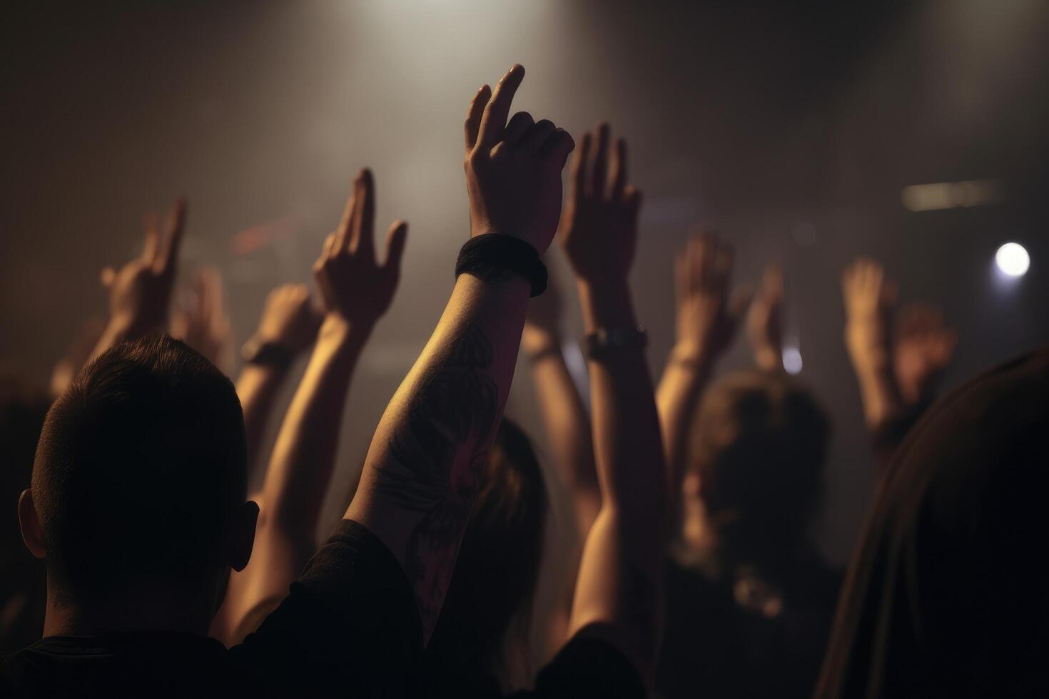 The crowd at a concert, hands raised up in the air. Peoples closeup rear view raising their hands, photo