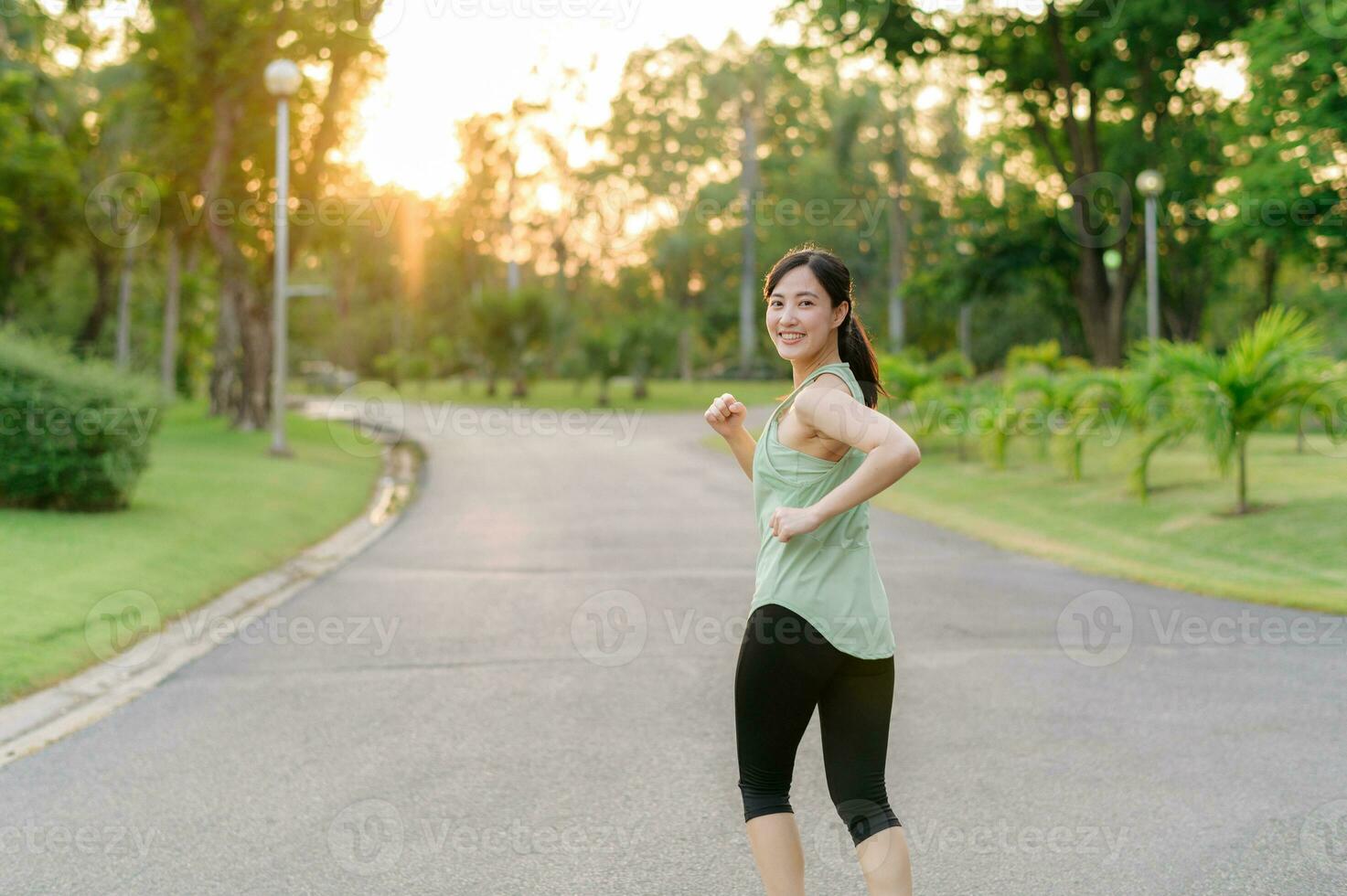 ajuste asiático joven mujer trotar en parque sonriente contento corriendo y disfrutando un sano al aire libre estilo de vida. hembra persona que practica jogging. aptitud corredor niña en público parque. sano estilo de vida y bienestar siendo concepto foto