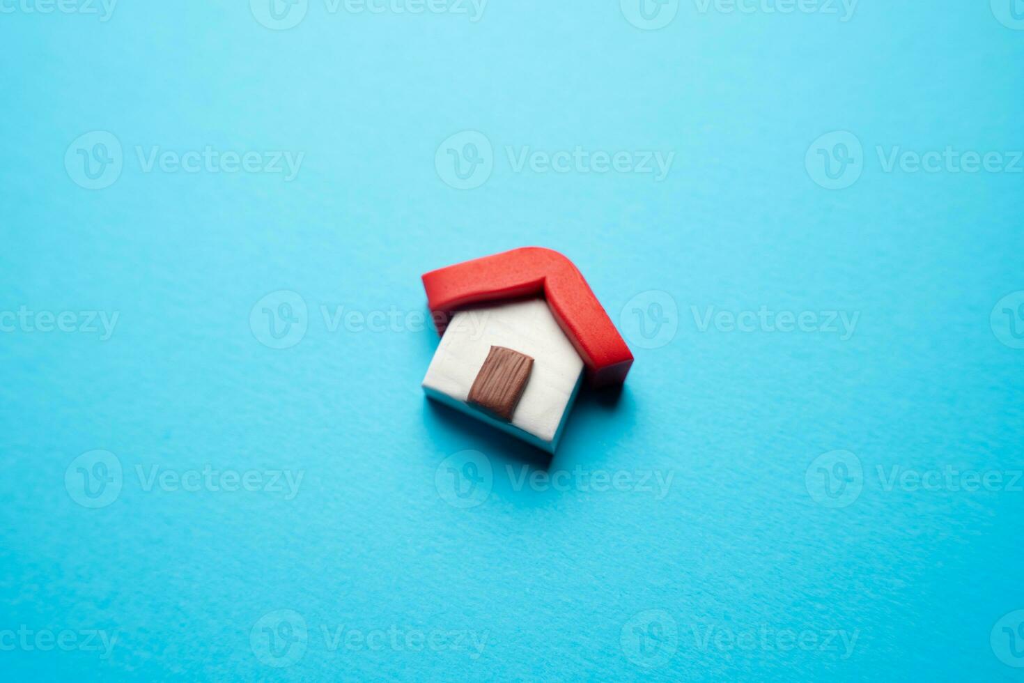 Miniature house on a blue background. Buying and selling housing. Design and architectural services. Real estate market review. Construction industry. Property insurance. photo