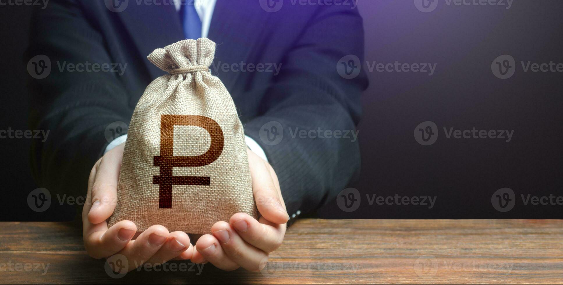 Businessman holds out russian ruble money bag. Getting a grant 