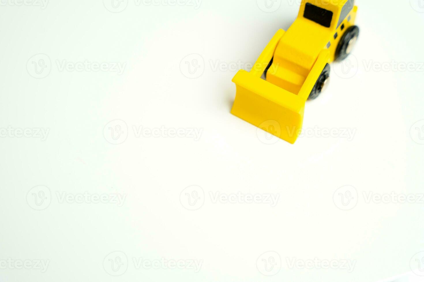 Toy yellow bulldozer and place for text on a white background. Demolition services, land leveling and other land works. Take down Illegal buildings. Industry machinery for rent photo