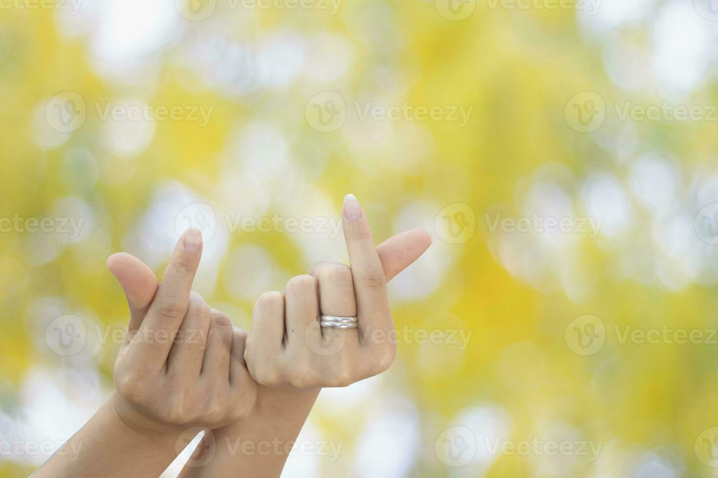 beautiful two finger mini heart of gril showing love finger shape heart closeup on green bokeh backgr photo