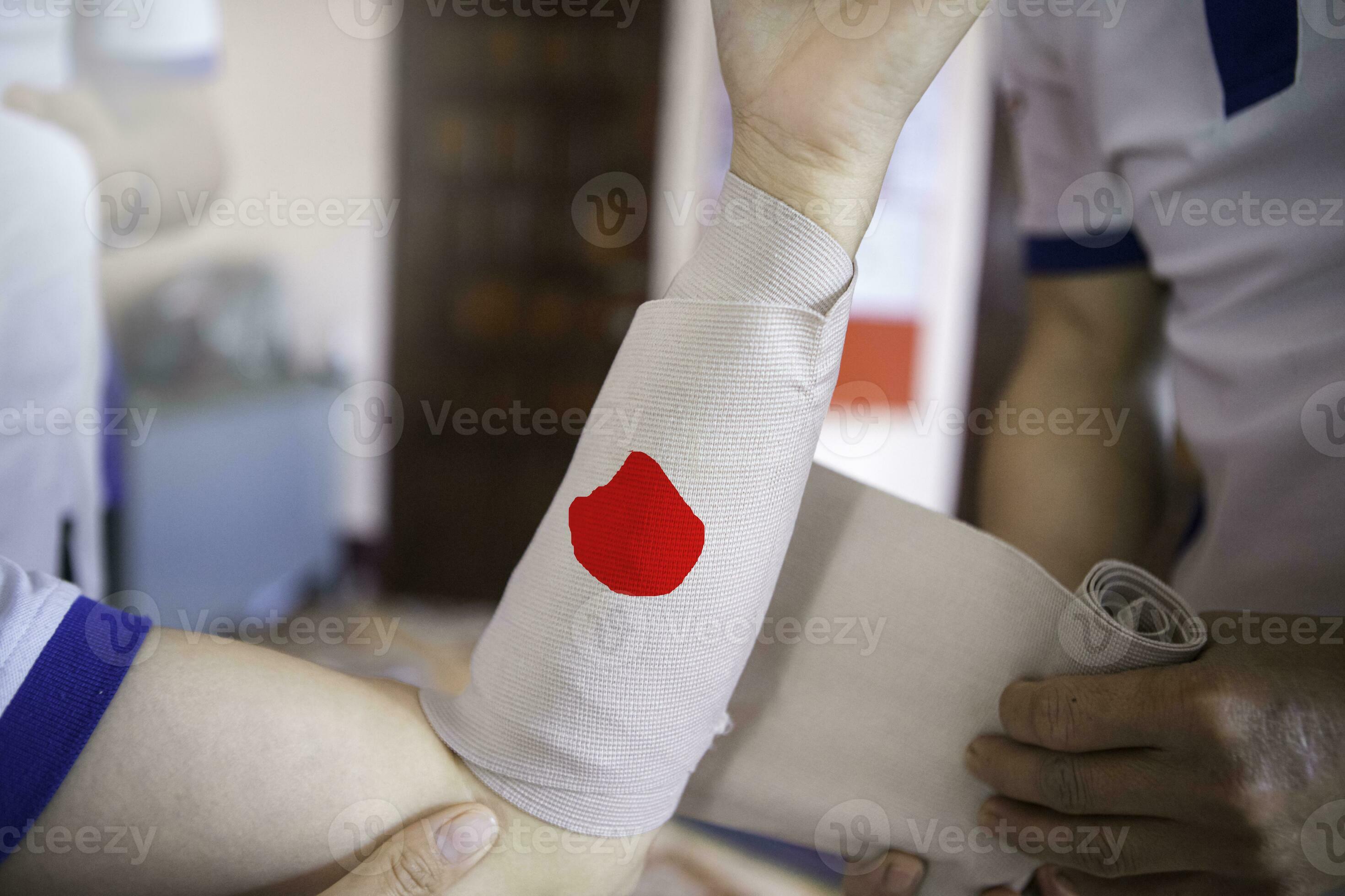 First aid training to wrap the wound around arm with bandage on arm to