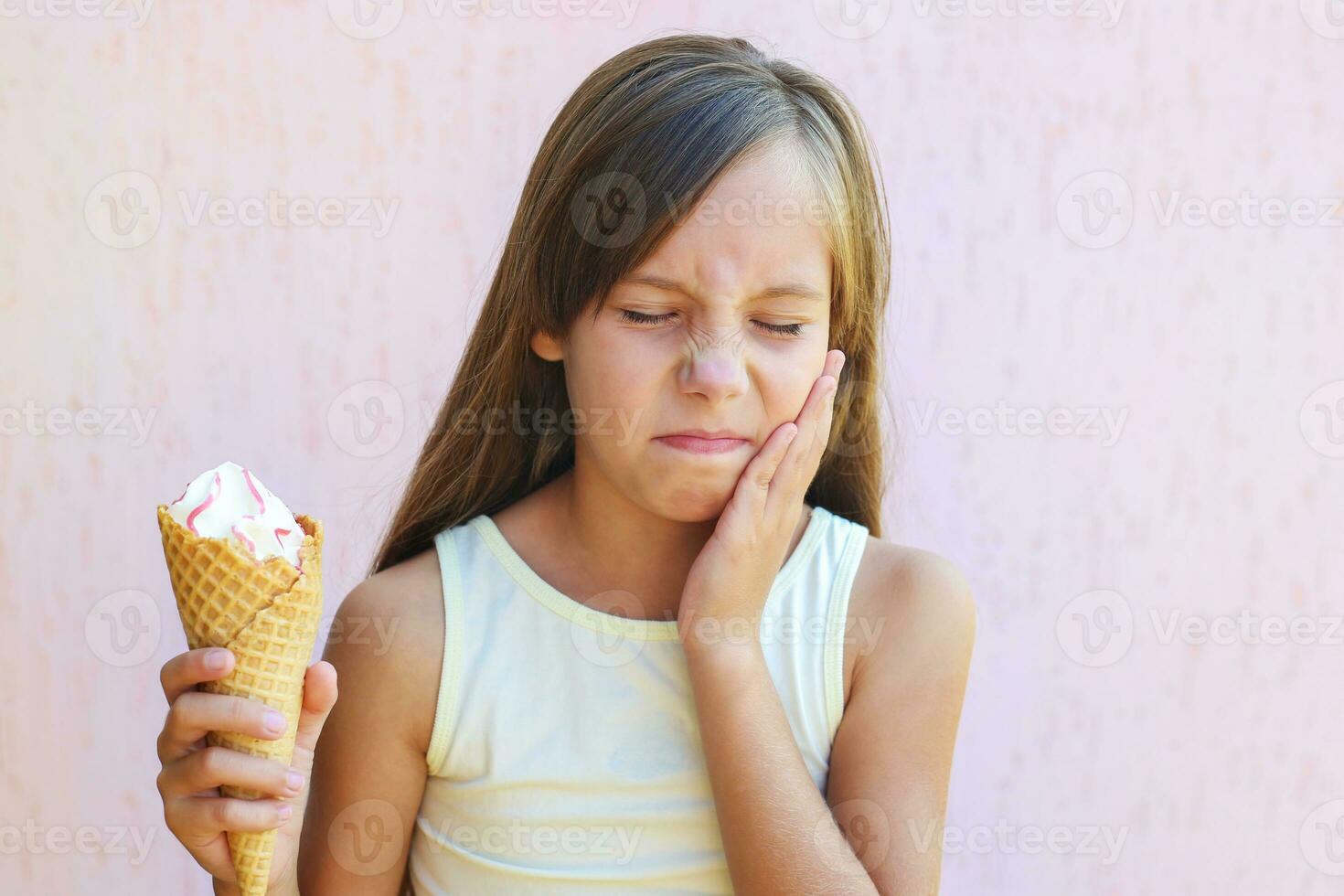 niña tiene un dolor de muelas desde frío hielo crema. foto