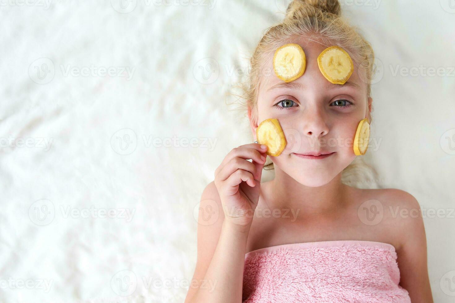 Beautiful girl with facial mask of bananas. Top view. Flat lay. photo