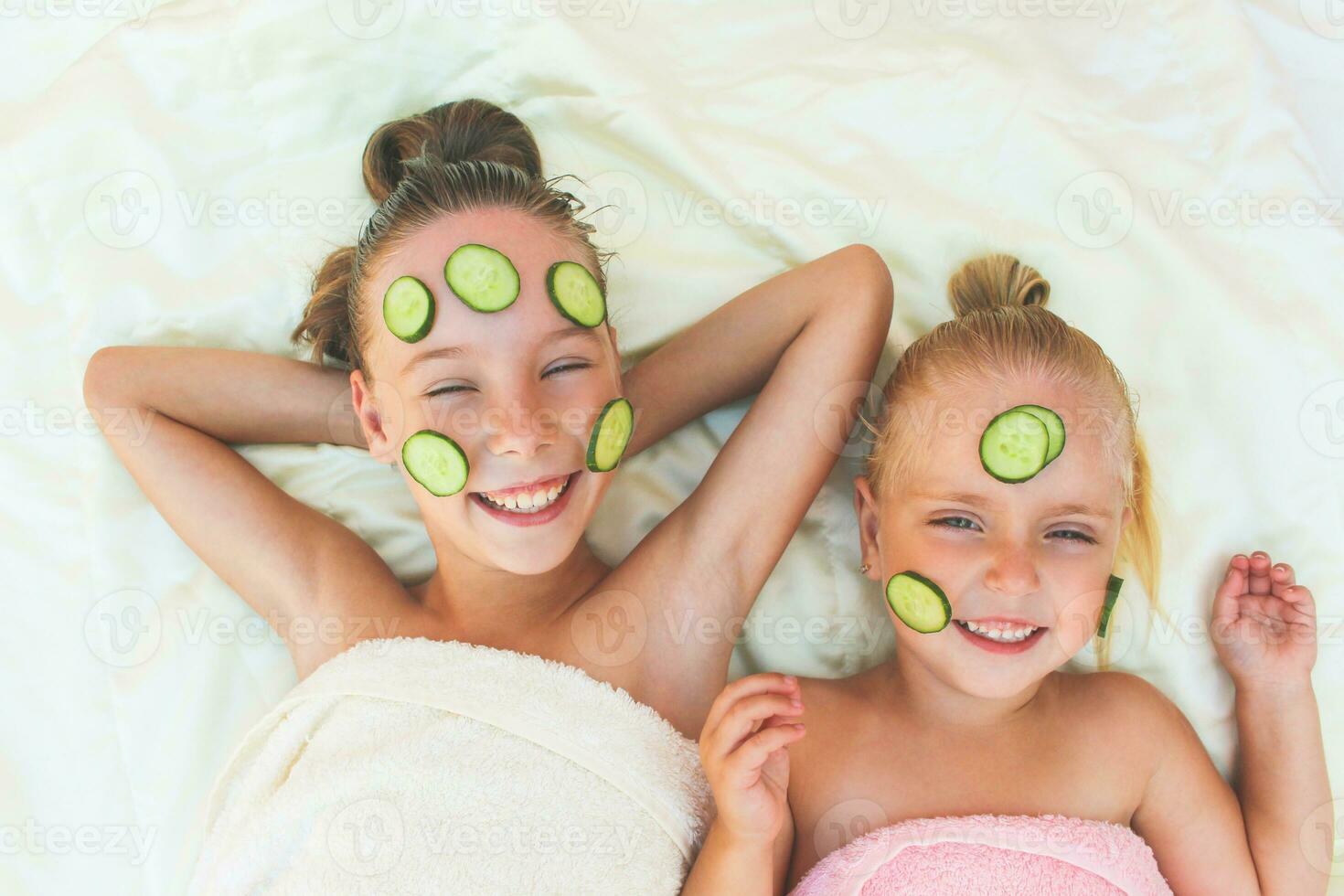 Beautiful girl with facial mask of cucumber. Toned image. Top view. photo