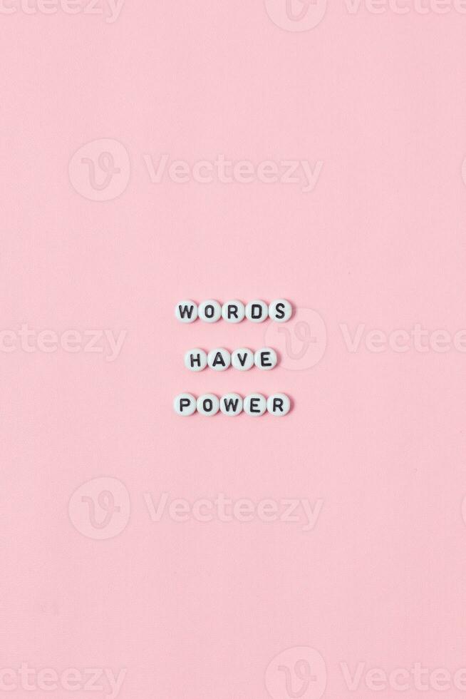 Top view of words have power quotes made out of beads on pink background. motivation and success concept photo