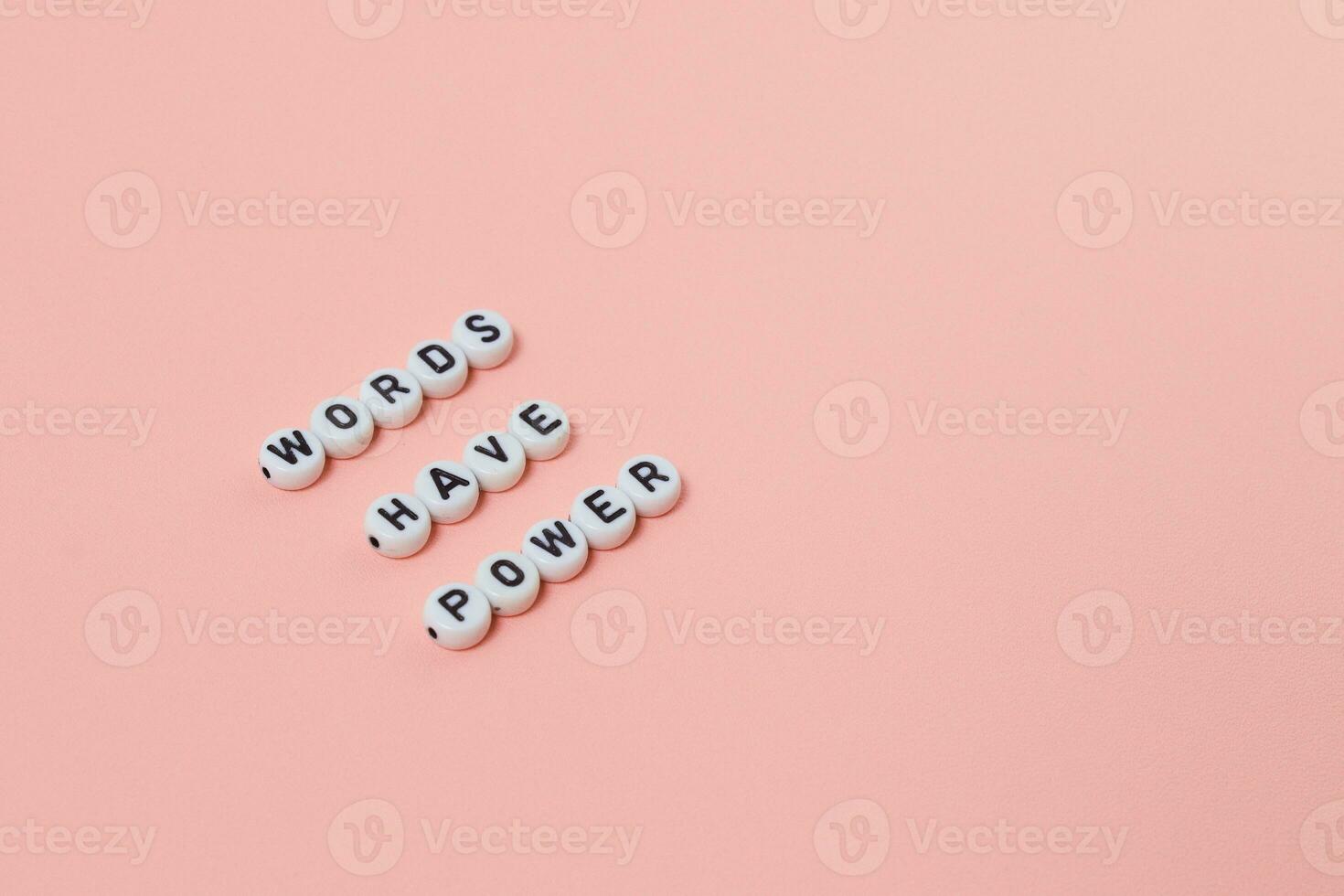 Top view of words have power quotes made out of beads on pink background. motivation and success concept photo