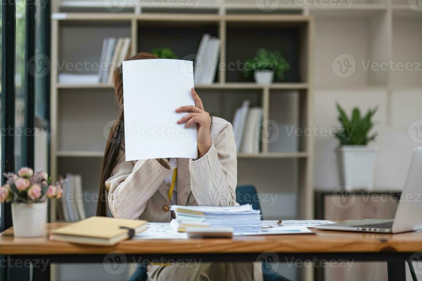 Portrait of a serious asian businesswoman thinking and concentrating typing on laptop at co-working spaces. Black screen laptop for graphic montage. Woman laptop working concept photo