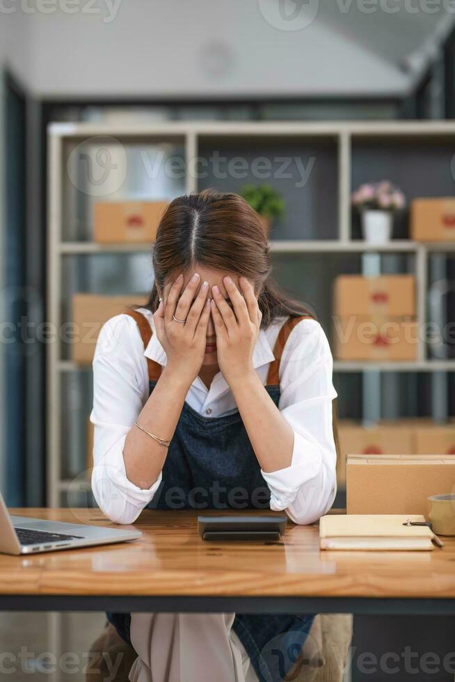 Small Business, Startup SME, Owner Entrepreneurs. Asian woman with unsuccess business online shopping crying and serious face unhappy mood. photo