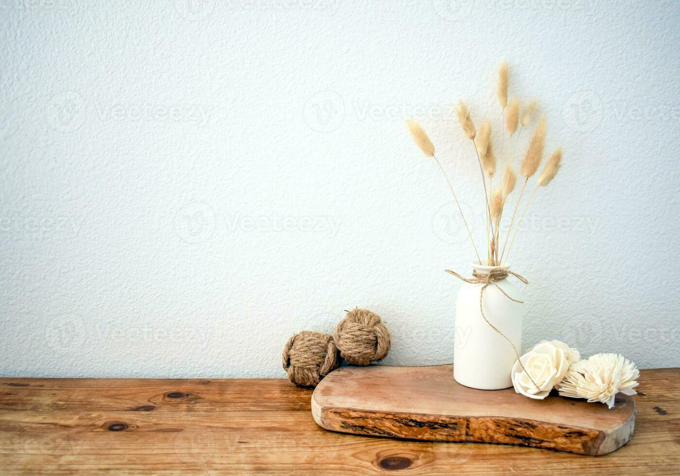 Stylish composition of table with beads and flowers and crown, bench in retro style, clay vases and crockery. Rustic inspiration. Summer vibes. Beige wood table. photo