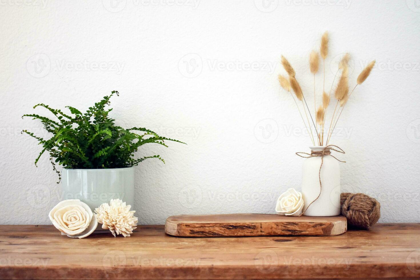 Stylish composition of table with beads and flowers and crown, bench in retro style, clay vases and crockery. Rustic inspiration. Summer vibes. Beige wood table. Plant. photo