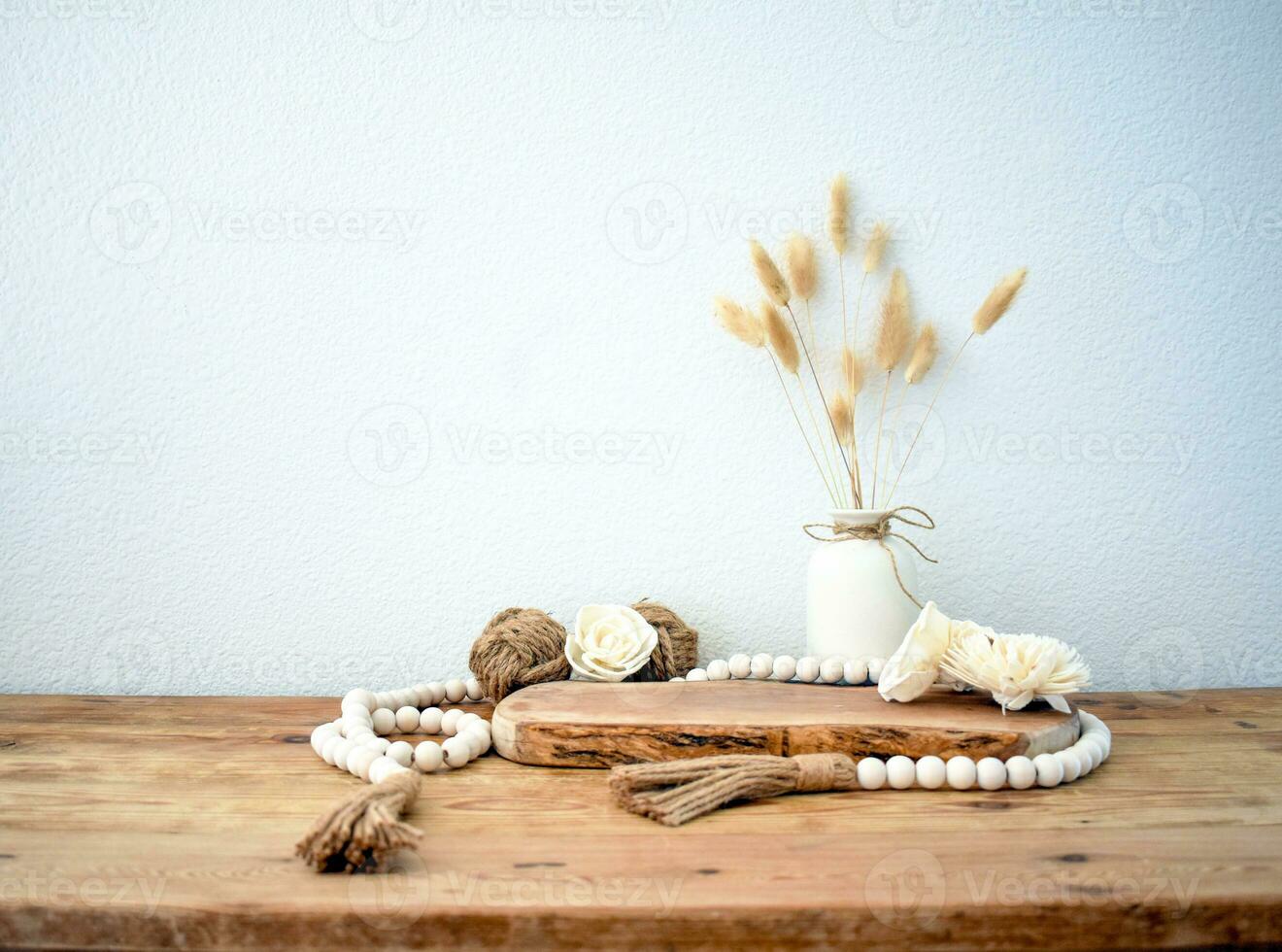 elegante composición de mesa con rosario y flores y corona, banco en retro estilo, arcilla floreros y vajilla. rústico inspiración. verano vibras. beige madera mesa. foto