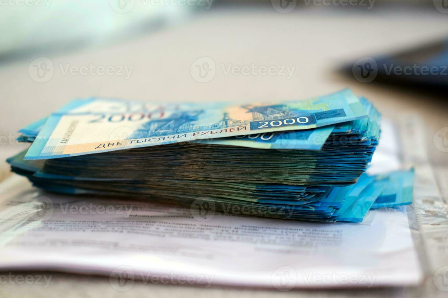 A stack of Russian rubles against the background of documents. Payment of contracts in rubles. Stack of money 2000 rubles photo