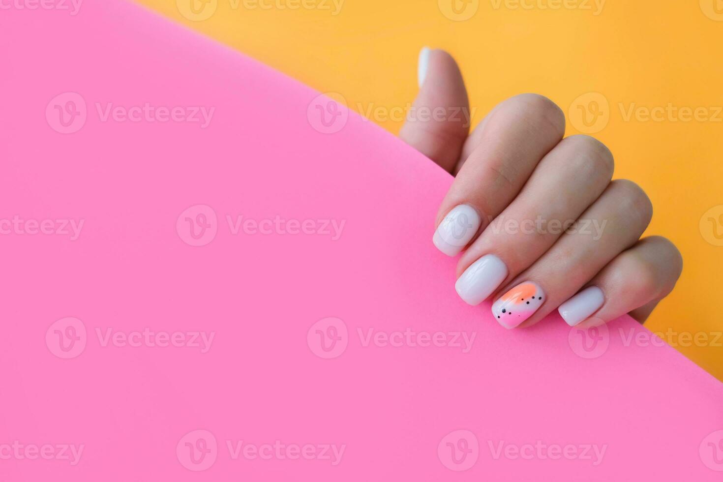 Beautiful female hands with a manicure on a pink and orange background. Shaded nail design. Summer manicure. Copy space. photo