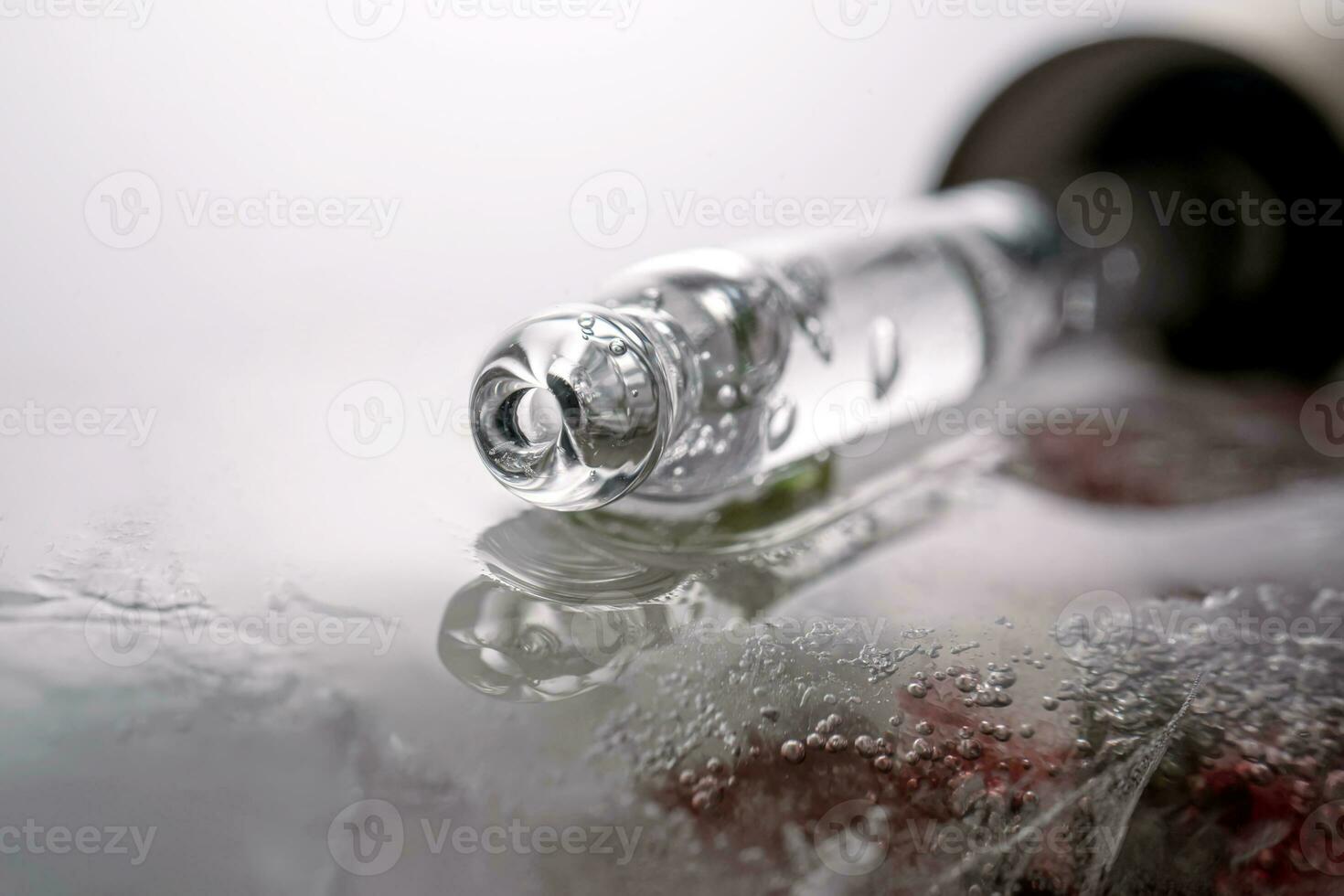 Pipette on a large piece of ice with frozen flowers. photo