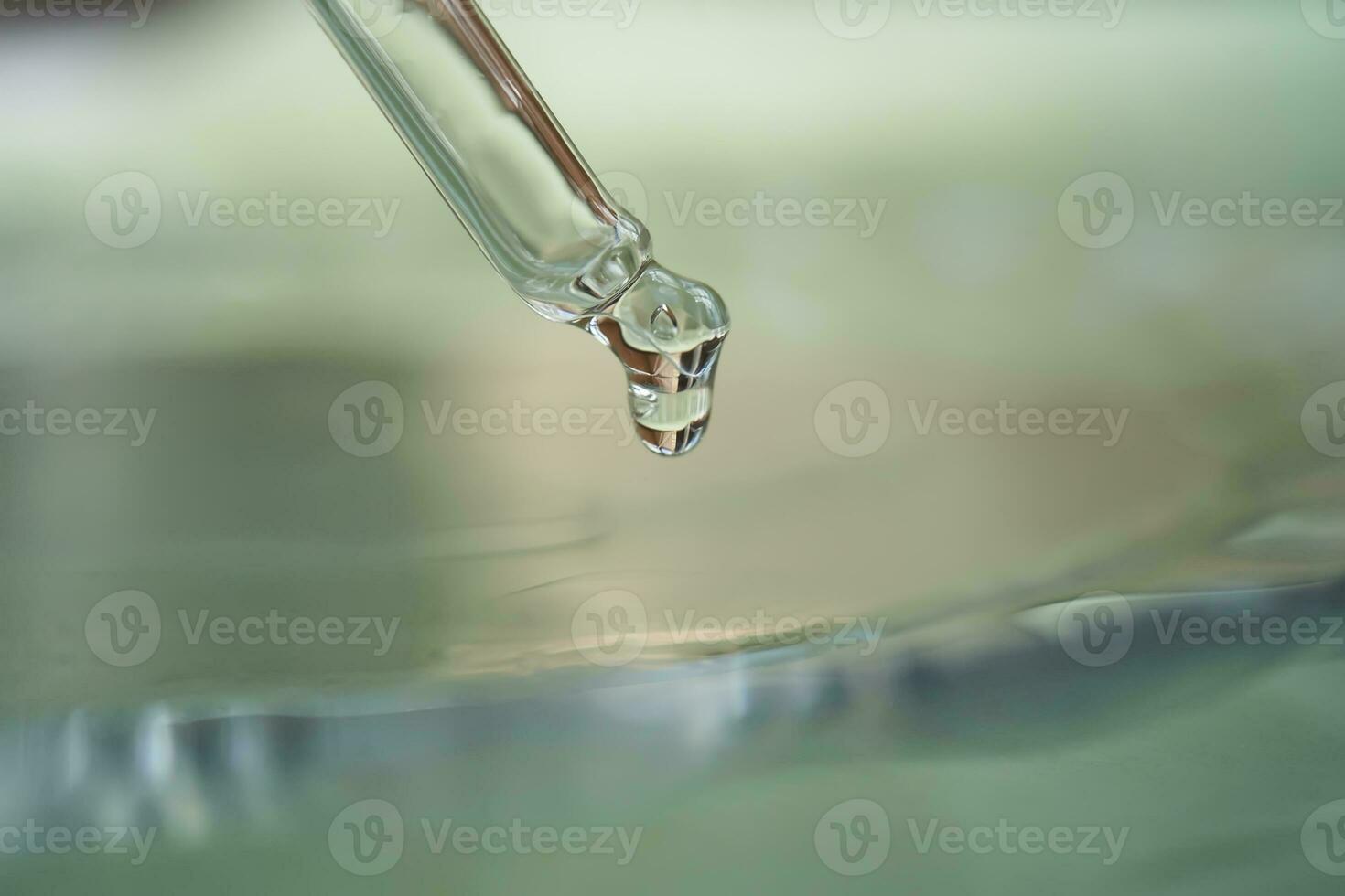 Dropper with serum or cosmetic oil on a green background. photo