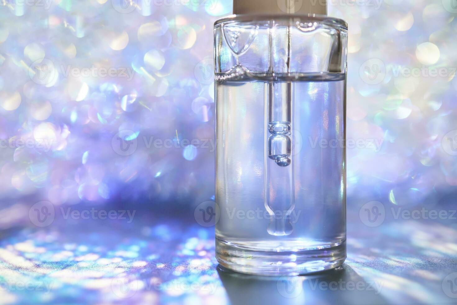 A bottle of serum with a pipette in tinsel in a Christmas theme in purple shades. photo