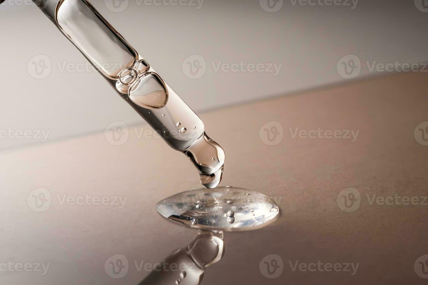 Pipette with serum, gel, oil or other cosmetic product on a beige background. photo