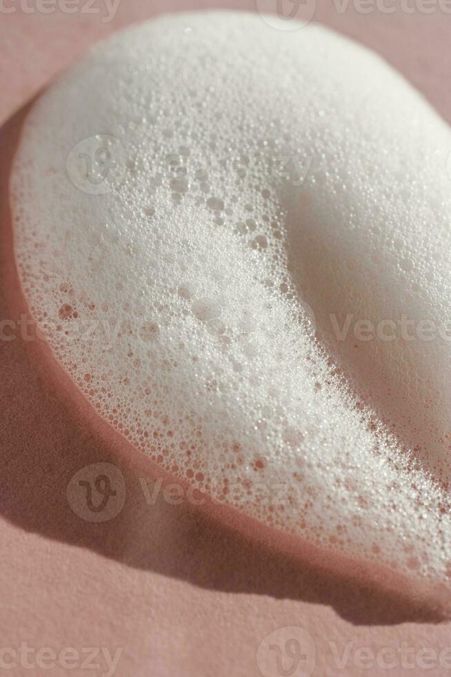 Texture of white foam on a pink background. photo