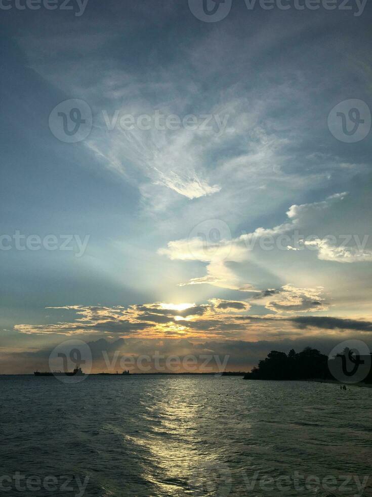 photo of the sunset sky with a sea view and island silhouette