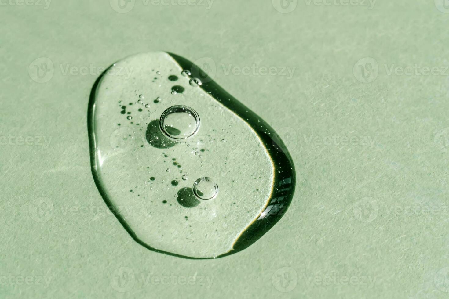 A drop of transparent cosmetic gel on a green background. photo