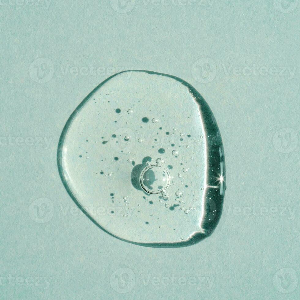 A drop of transparent cosmetic gel on a green background. photo