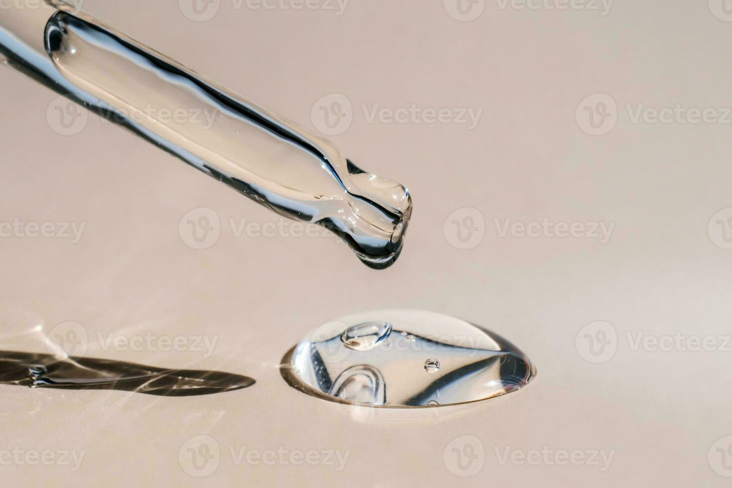 A drop of cosmetic oil falls from the pipette photo