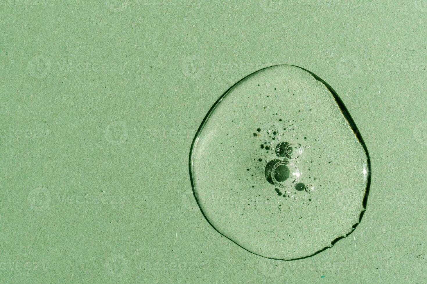A drop of transparent cosmetic gel on a green background. photo
