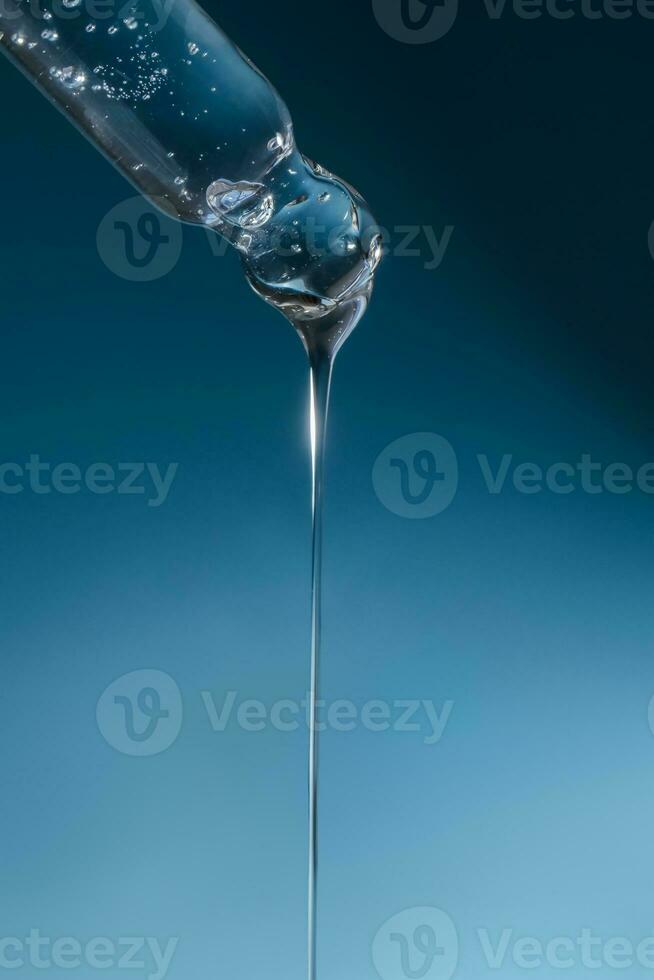 Pipette with transparent serum on the background of shells. photo